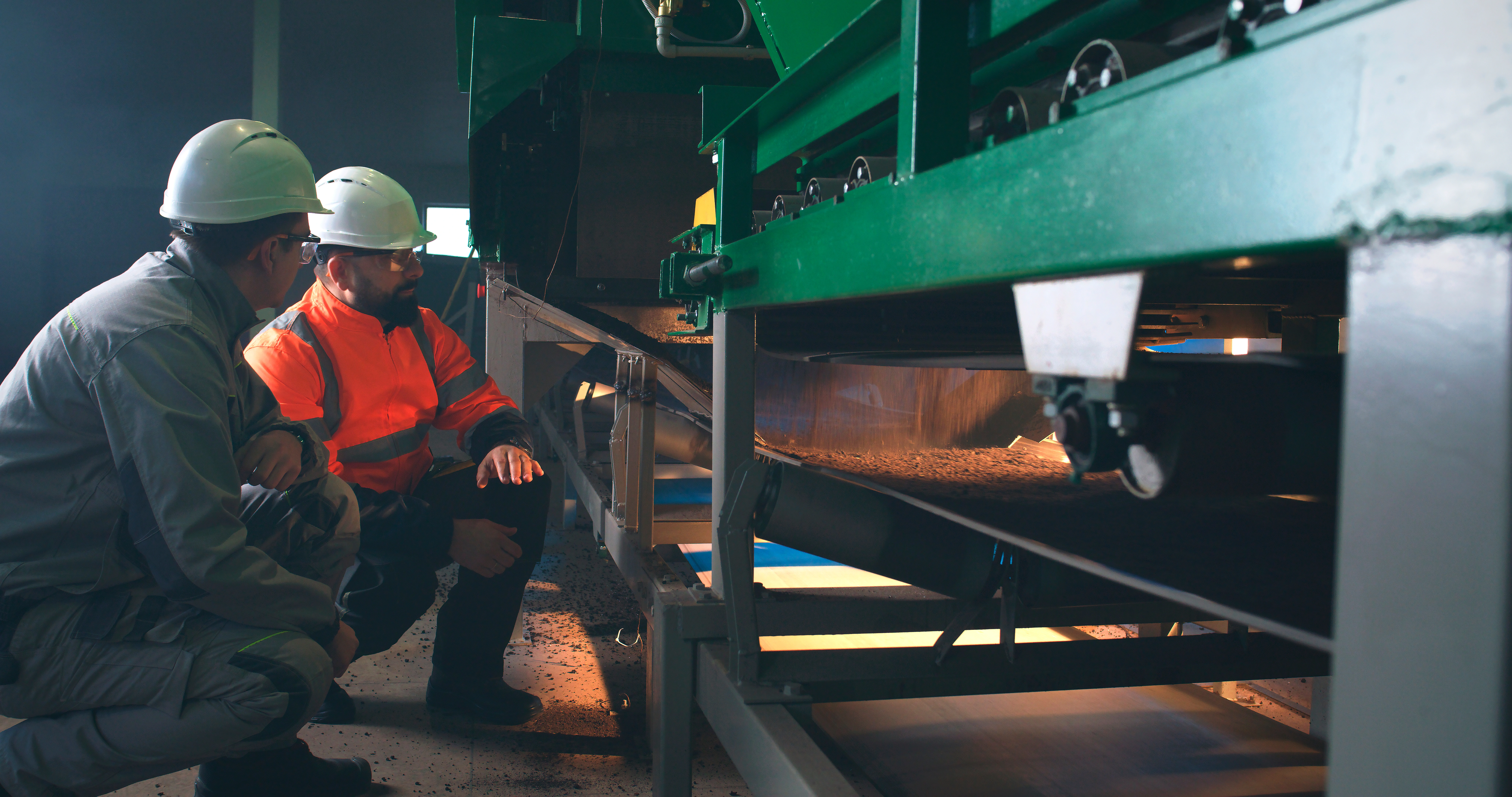 Personnel inspecting the idlers of a conveyor belt